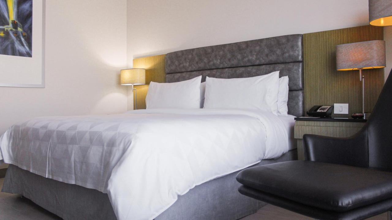 Holiday Inn Bucaramanga Cacique By Ihg Eksteriør bilde A bed with a duvet